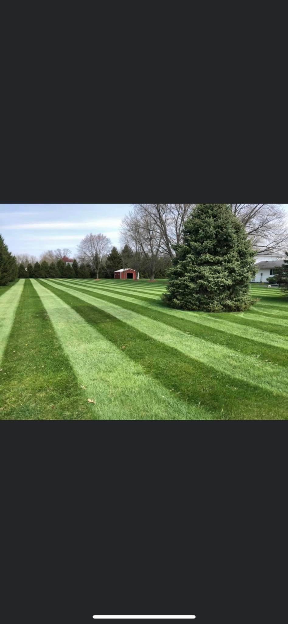 Professional mowing with barn in background